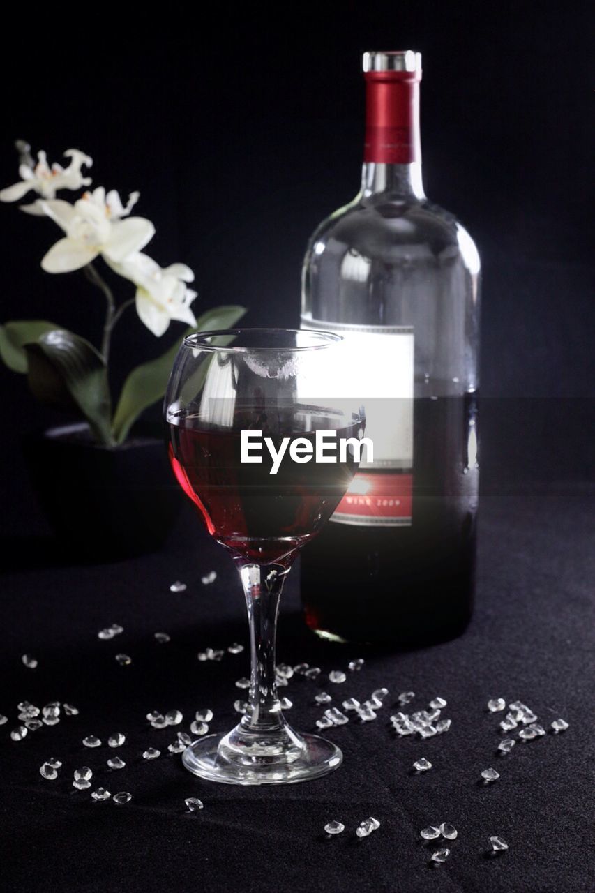 Red wine bottle and glass on table