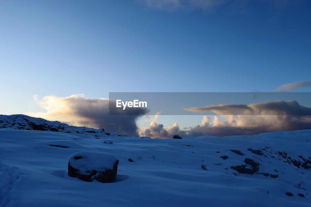 Scenic view of snow mountains against blue sky