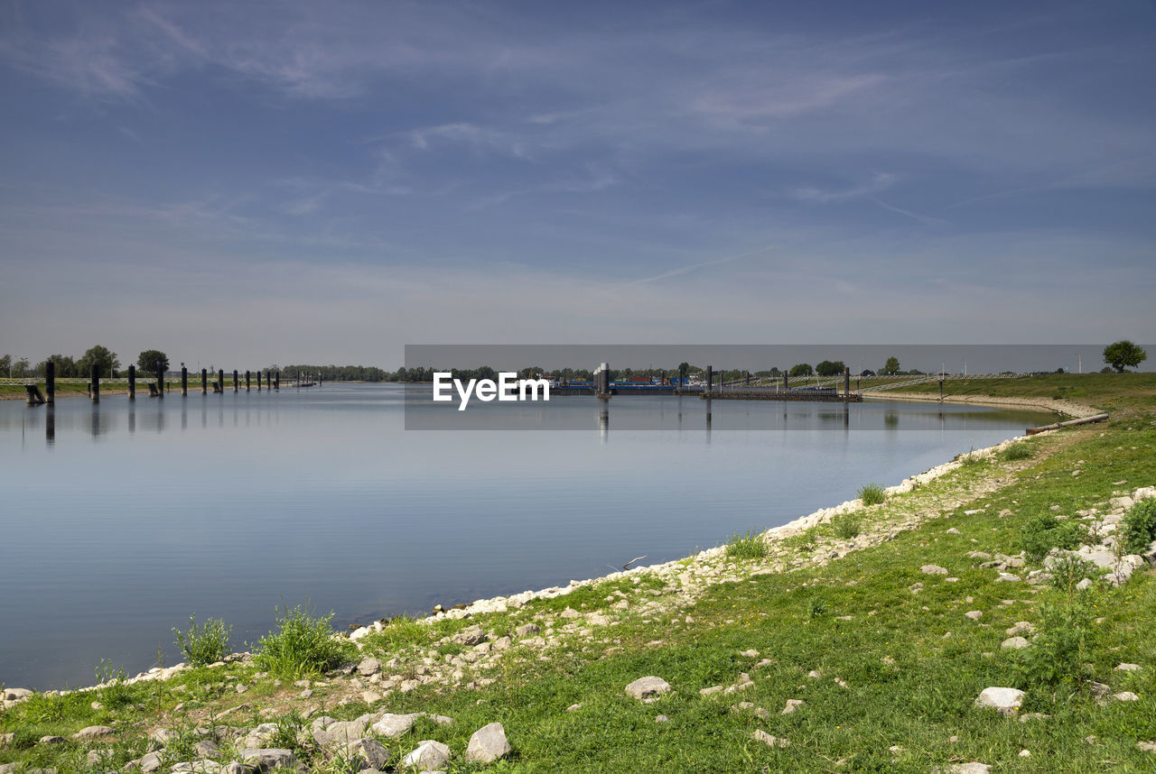 SCENIC VIEW OF LAKE BY PLANTS AGAINST SKY
