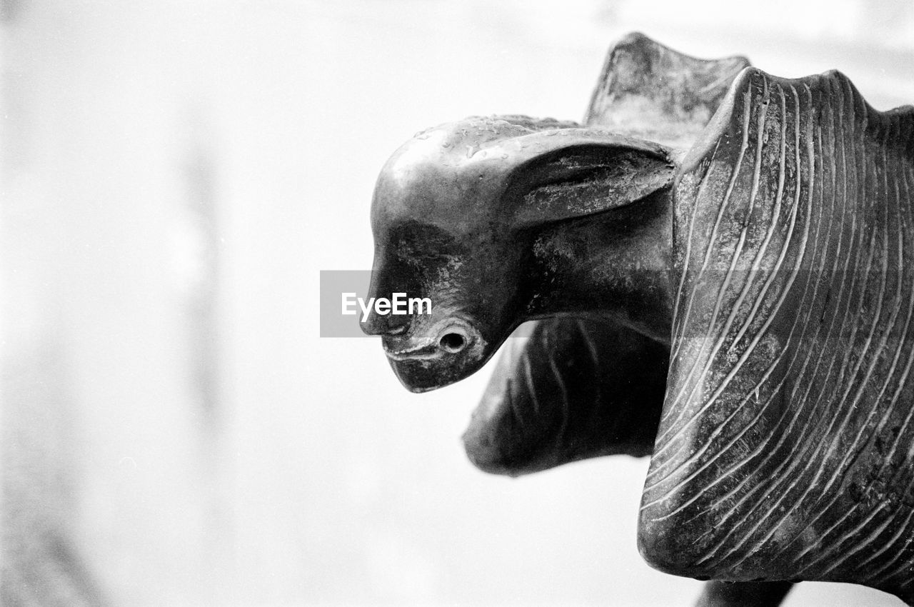 CLOSE-UP OF LION STATUE AGAINST SKY