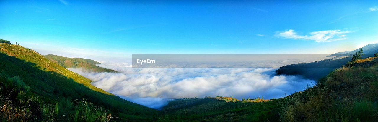 Panoramic view of mountains against blue sky