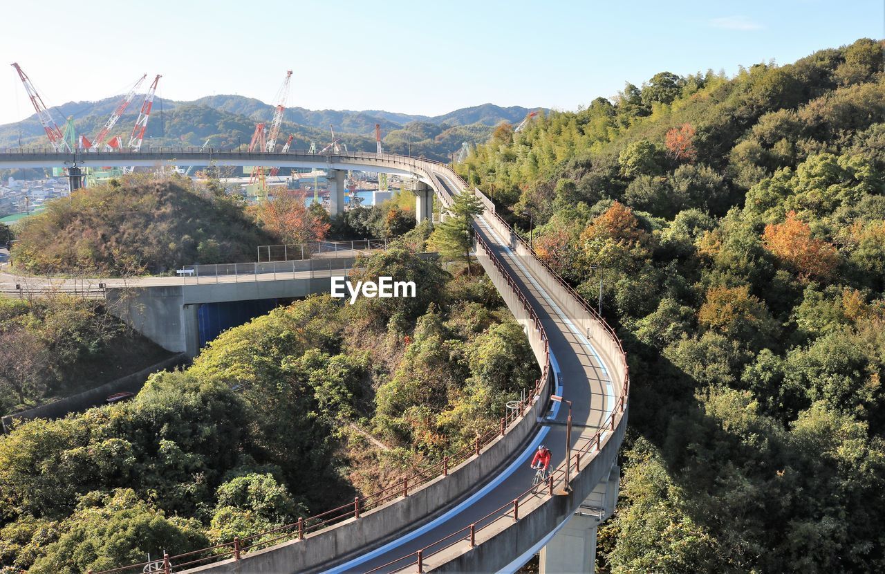 High angle view of cyclist on bridge against sky