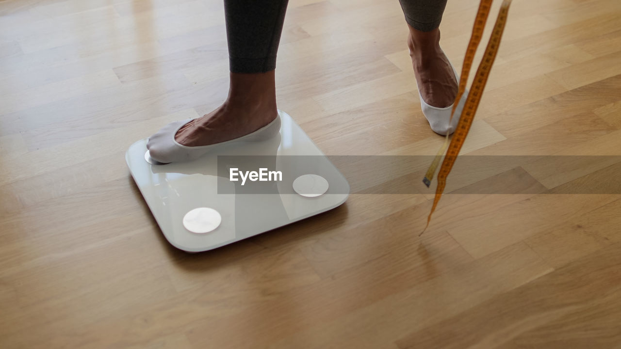 flooring, hardwood floor, wood, indoors, floor, one person, low section, human leg, lifestyles, adult, home interior, domestic life, cleaning, parquet floor, limb, human limb, shoe, standing, high angle view, women, laminate flooring, broom, men