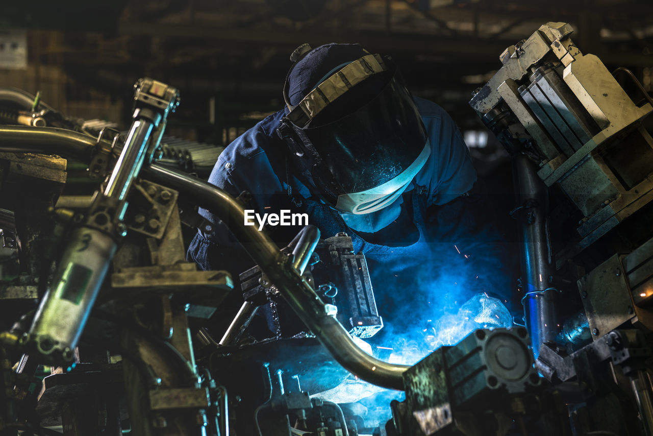 Worker welding at factory