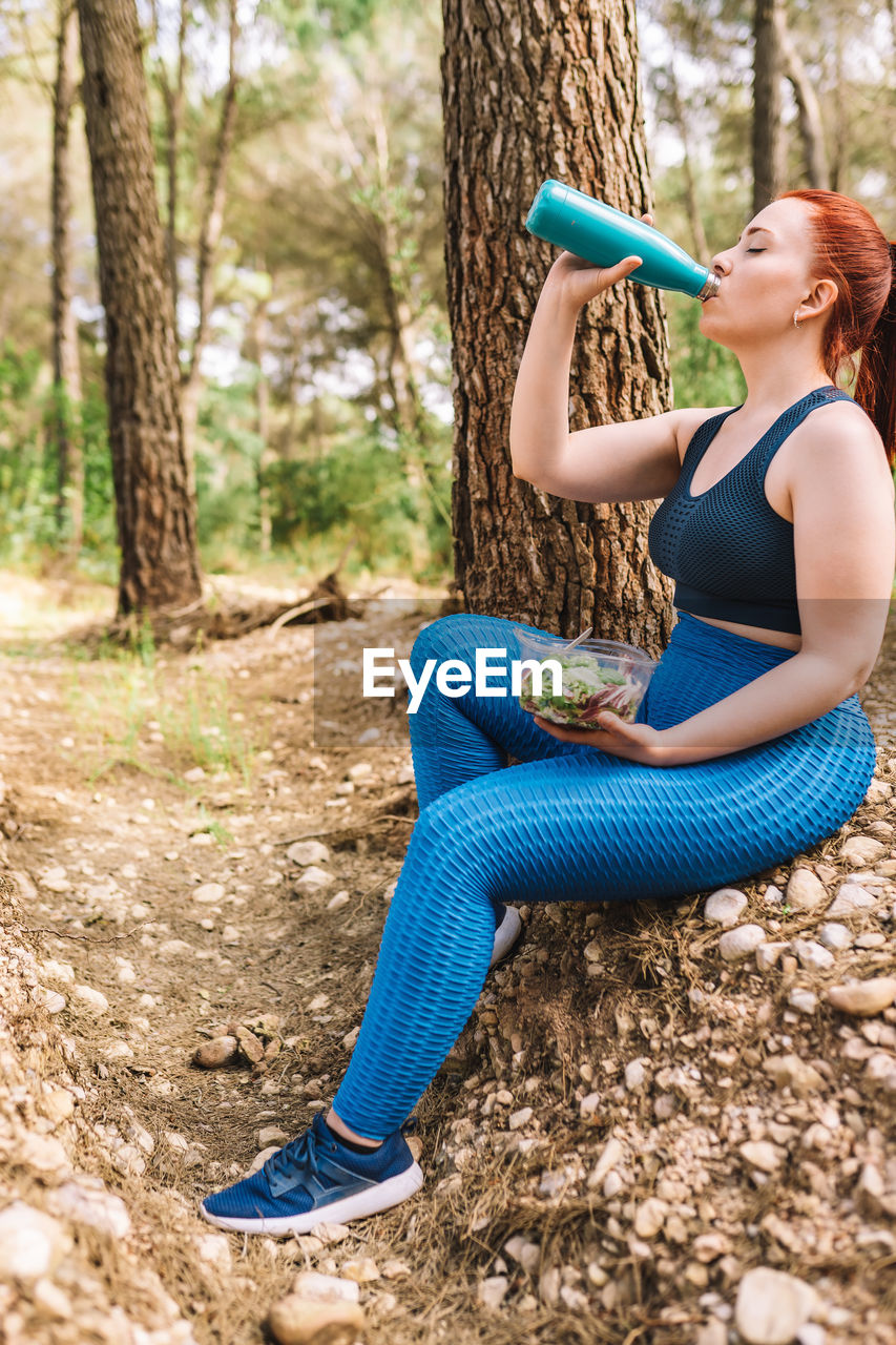 side view of young woman exercising on field