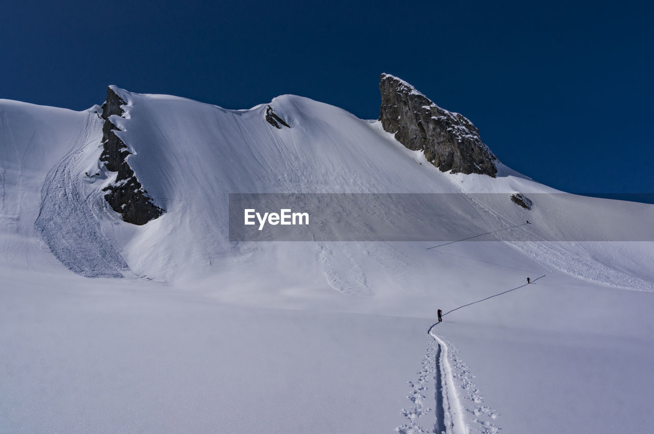 Scenic view of snow covered mountains against clear sky