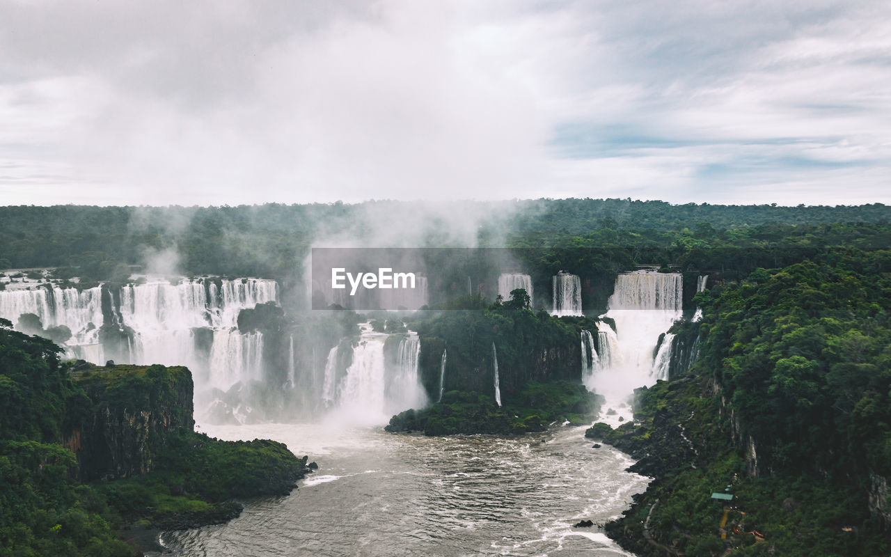 Scenic view of waterfall against sky