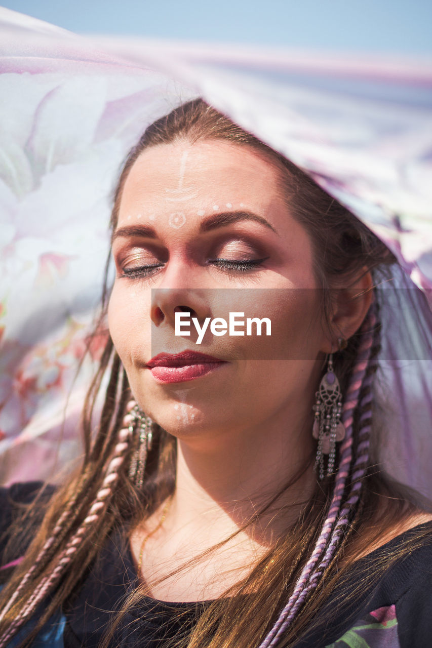 Close up woman with tribal makeup and thin fabric portrait picture