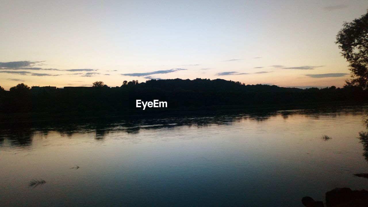 SCENIC VIEW OF LAKE AGAINST SKY AT DUSK