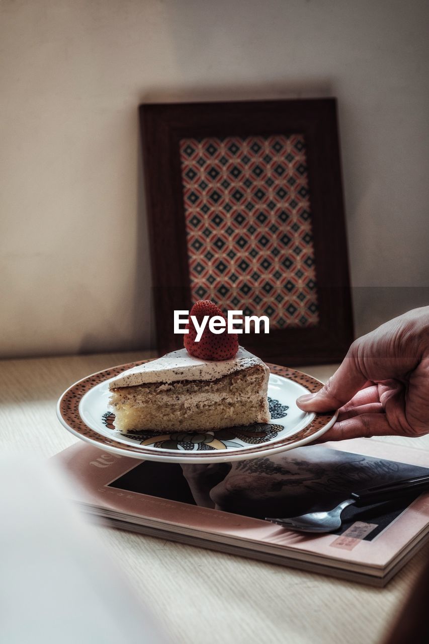 Midsection of person with ice cream on table