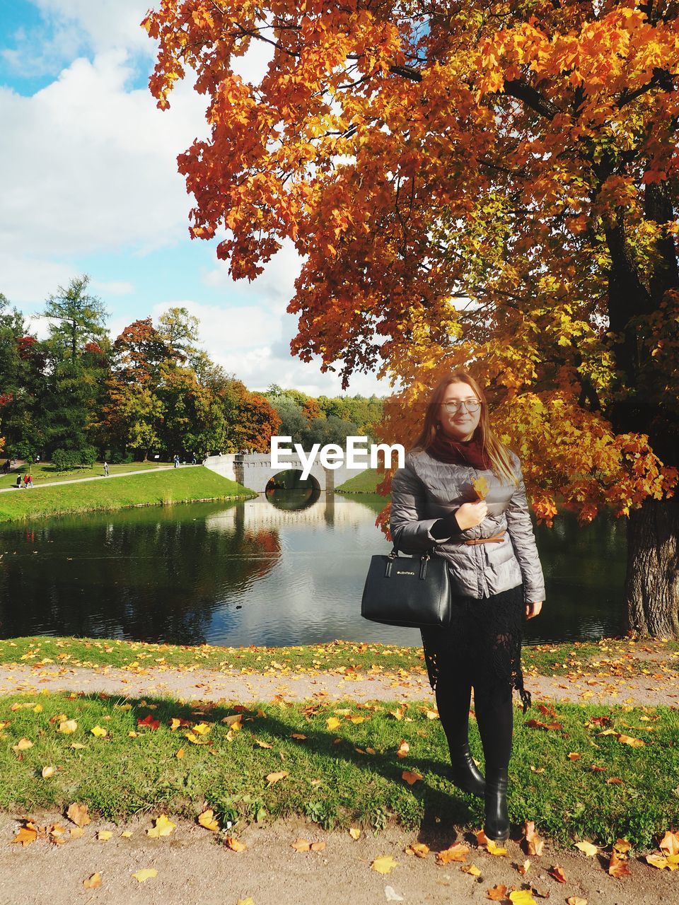 PORTRAIT OF YOUNG WOMAN WITH AUTUMN LEAVES