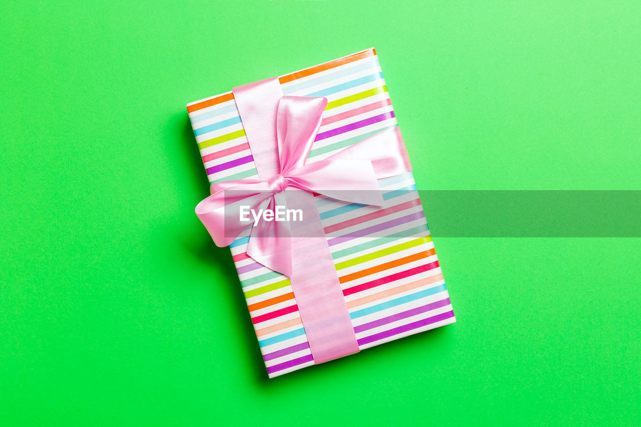 Gift box on colored background top view with copy space. holiday concept.