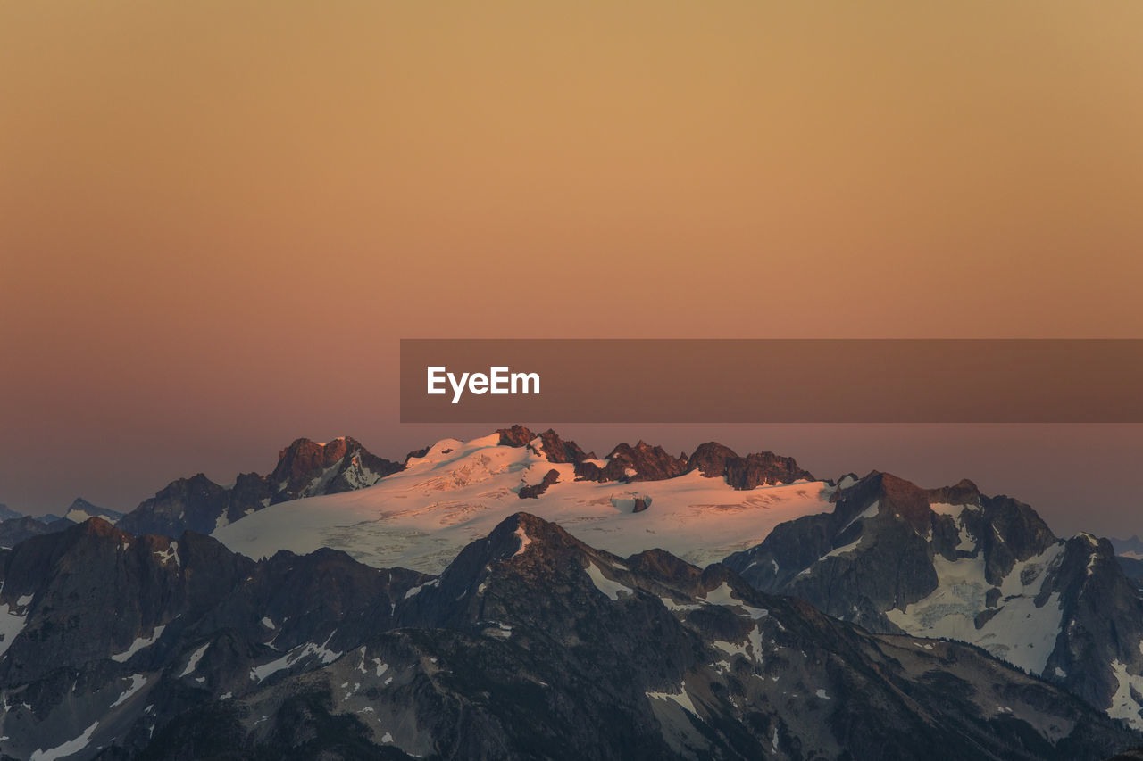 Alpenglow on glacier and mountain peaks, washington state, usa.