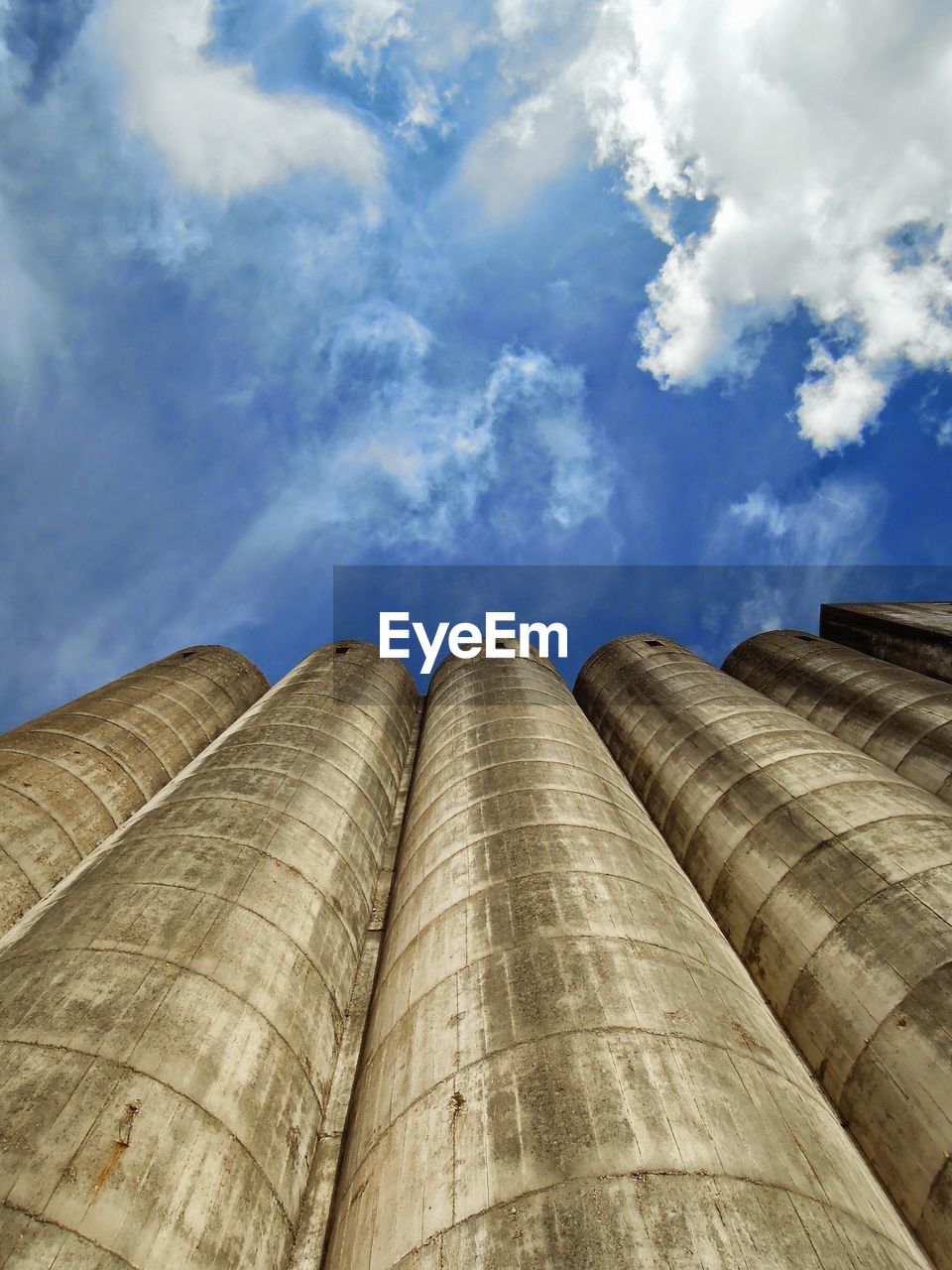 LOW ANGLE VIEW OF TALL BUILDING AGAINST CLOUDY SKY