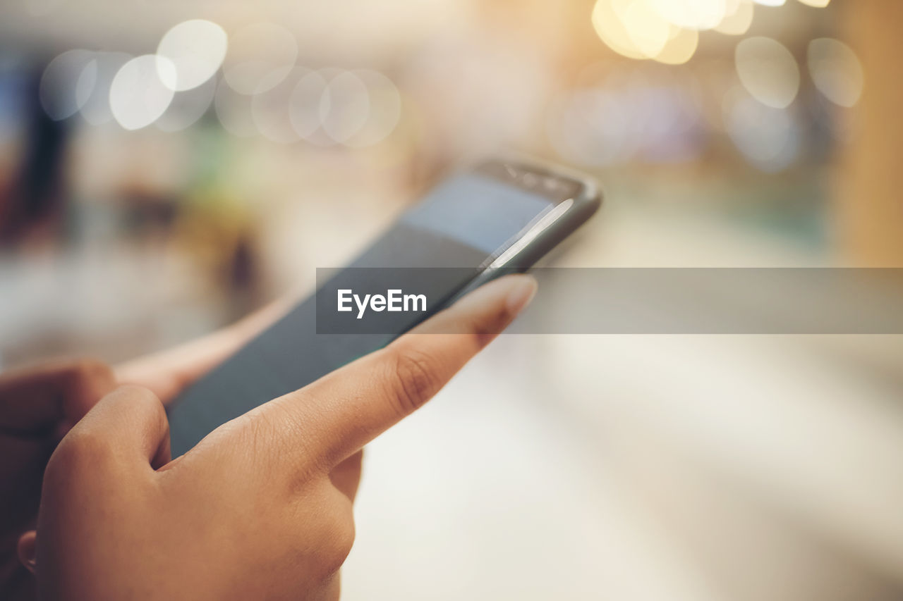 The hand of a woman using a smartphone.this image is soft focus.