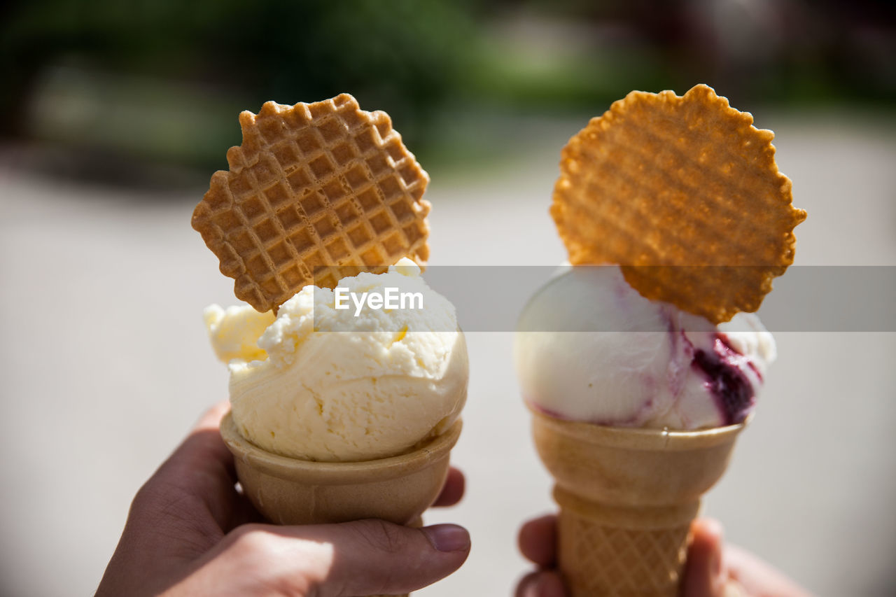 Cropped hands holding ice cream cones