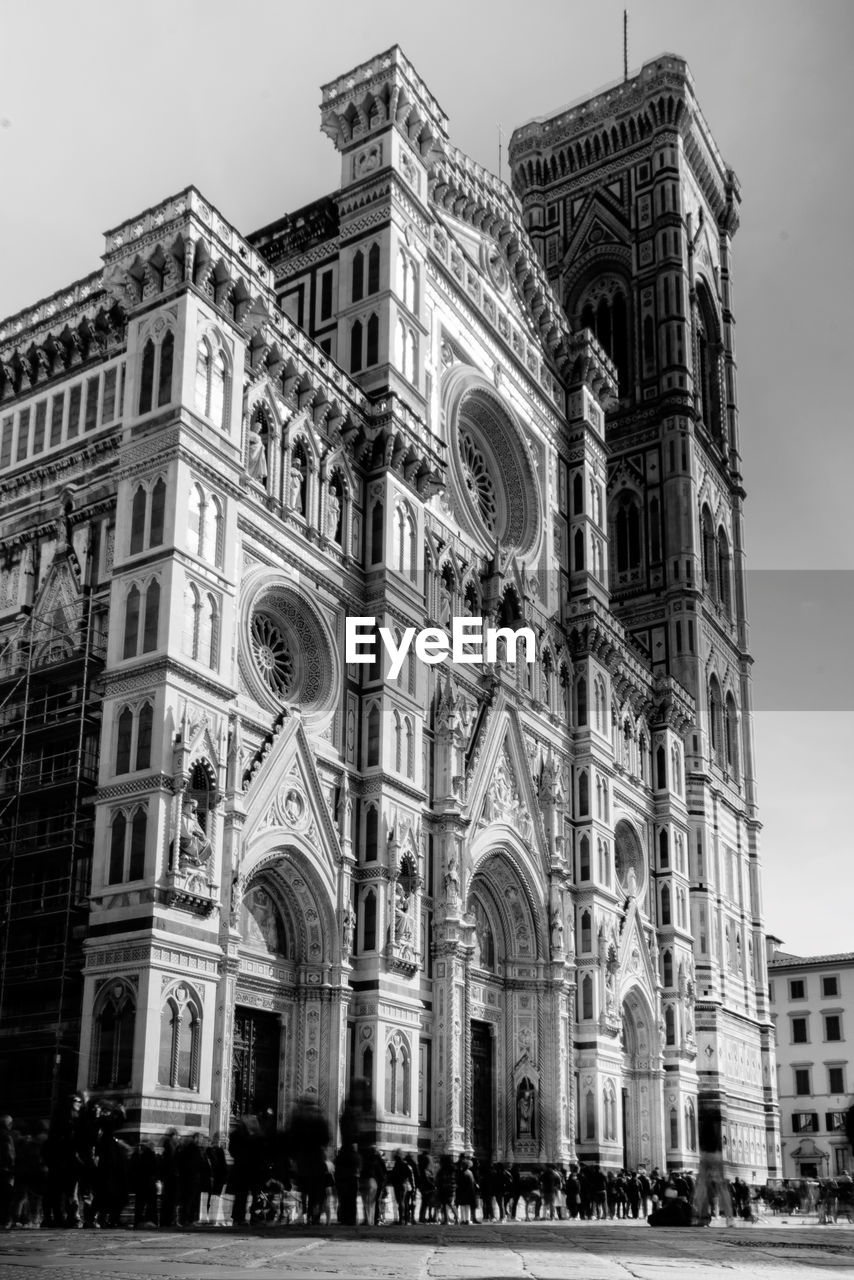 architecture, building exterior, built structure, black and white, city, travel destinations, monochrome, building, history, place of worship, landmark, the past, religion, monochrome photography, belief, sky, metropolis, travel, facade, spirituality, tourism, arch, group of people, worship, nature, catholicism, large group of people, low angle view, day, crowd, outdoors, street, cityscape