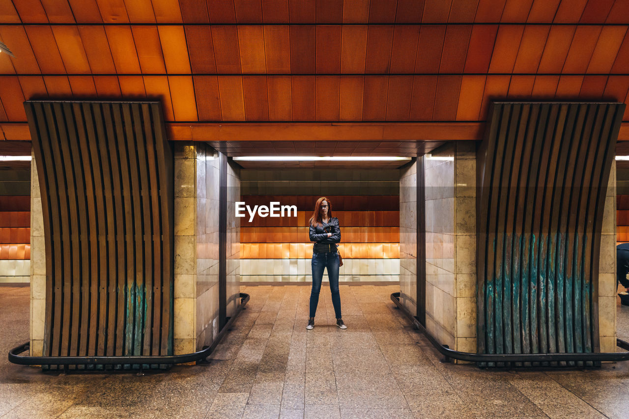 Full length portrait of woman standing in metro