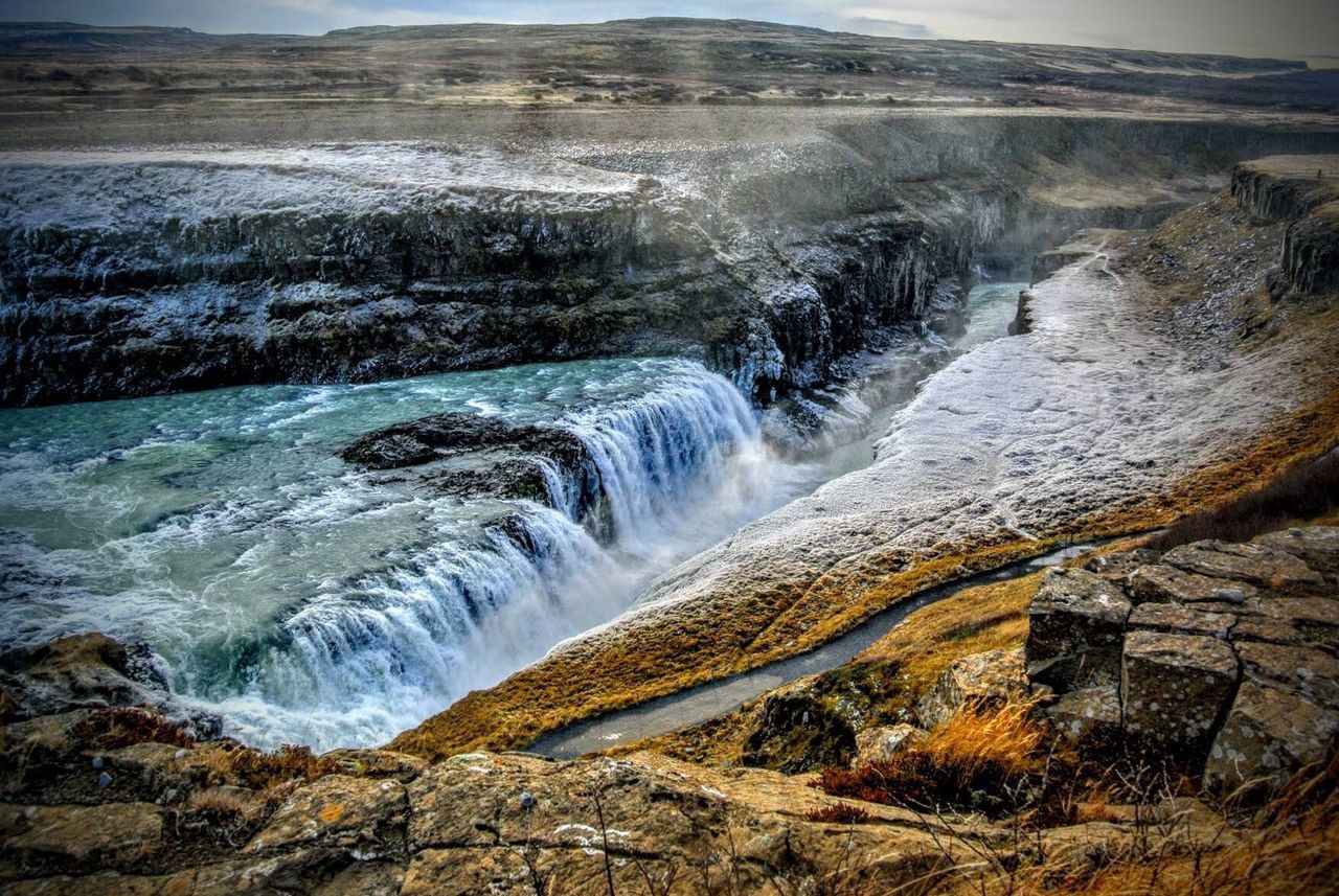 SCENIC VIEW OF WATERFALL AGAINST SKY