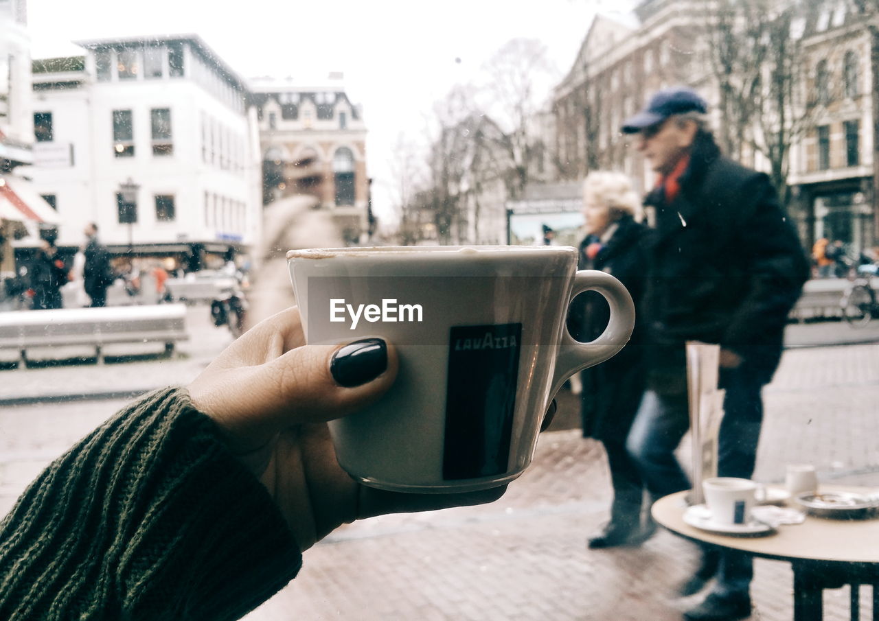 WOMAN PHOTOGRAPHING THROUGH SMART PHONE IN PARK