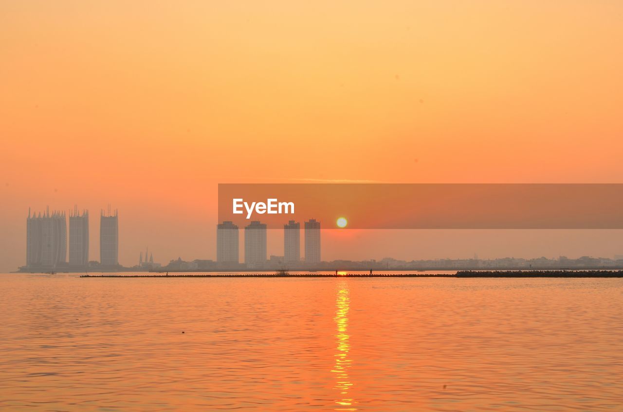 SCENIC VIEW OF BUILDINGS AGAINST ORANGE SKY