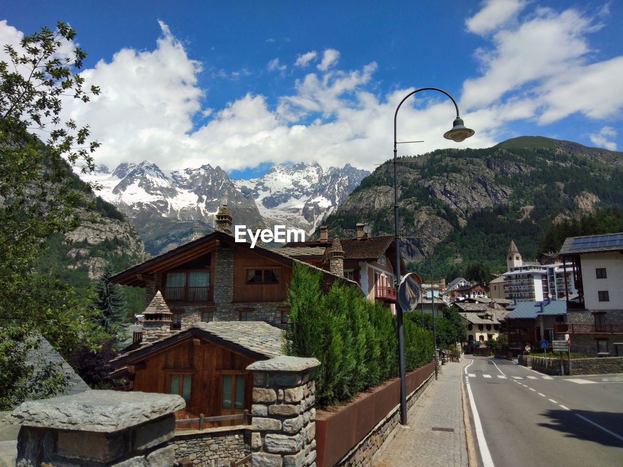 Street amidst buildings and mountains against sky