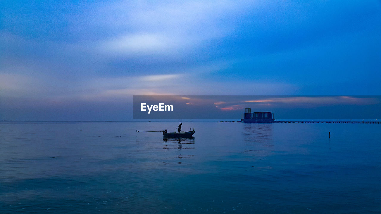 SILHOUETTE OF SHIP IN SEA AGAINST SKY