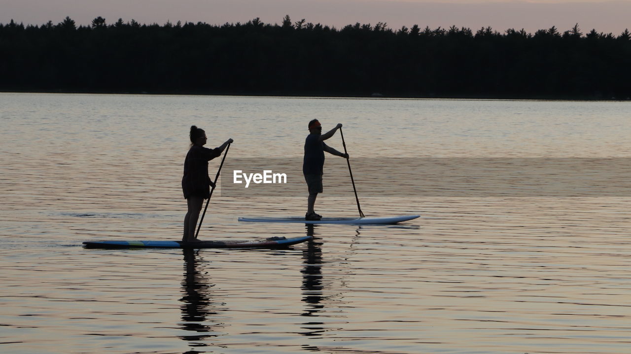 SILHOUETTE PEOPLE IN LAKE