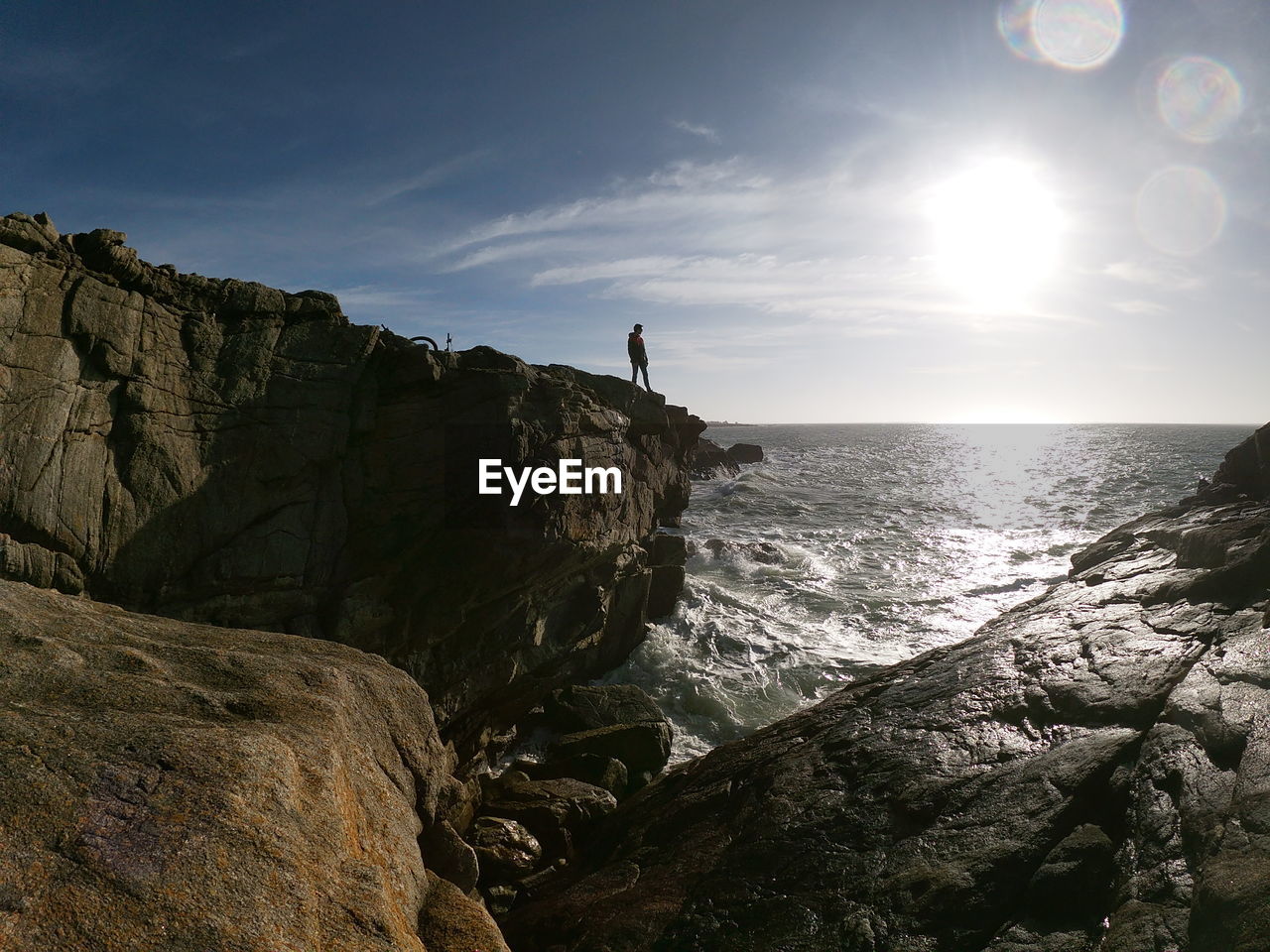 ROCK FORMATIONS ON SHORE AGAINST SKY