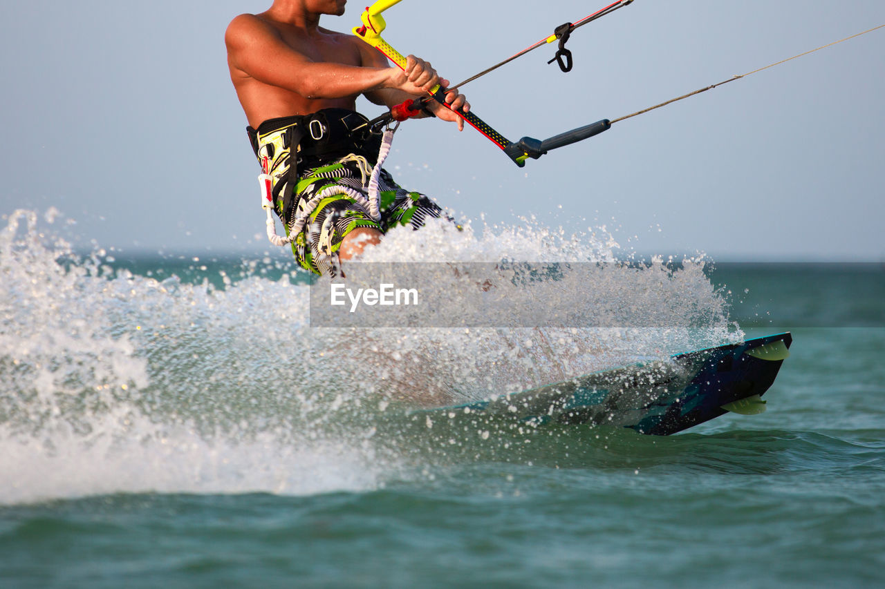 Man wakeboarding in sea against sky