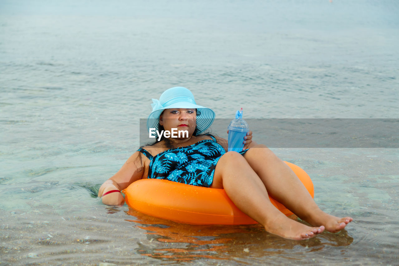 rear view of boy playing in sea against sky