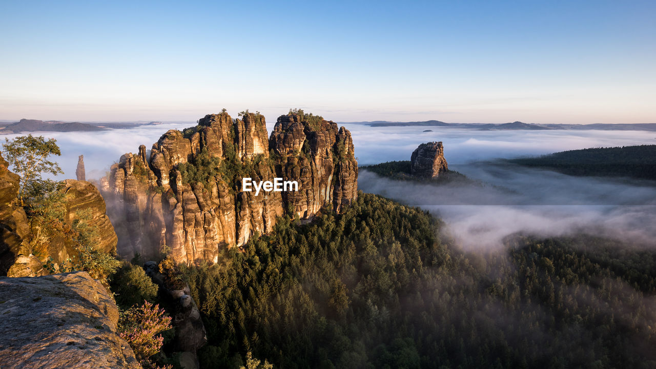 High angle view of rock formations by clouds against sky