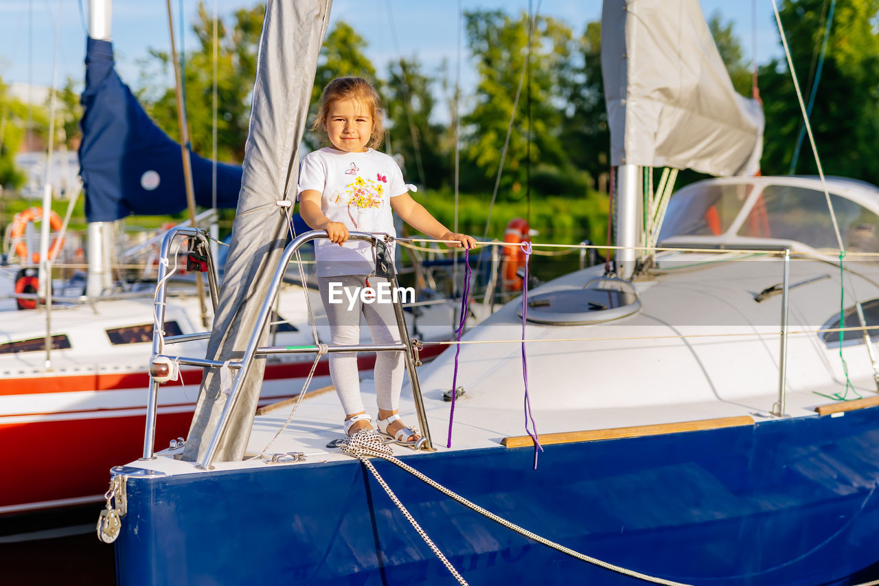 Portrait of cute girl standing on yacht