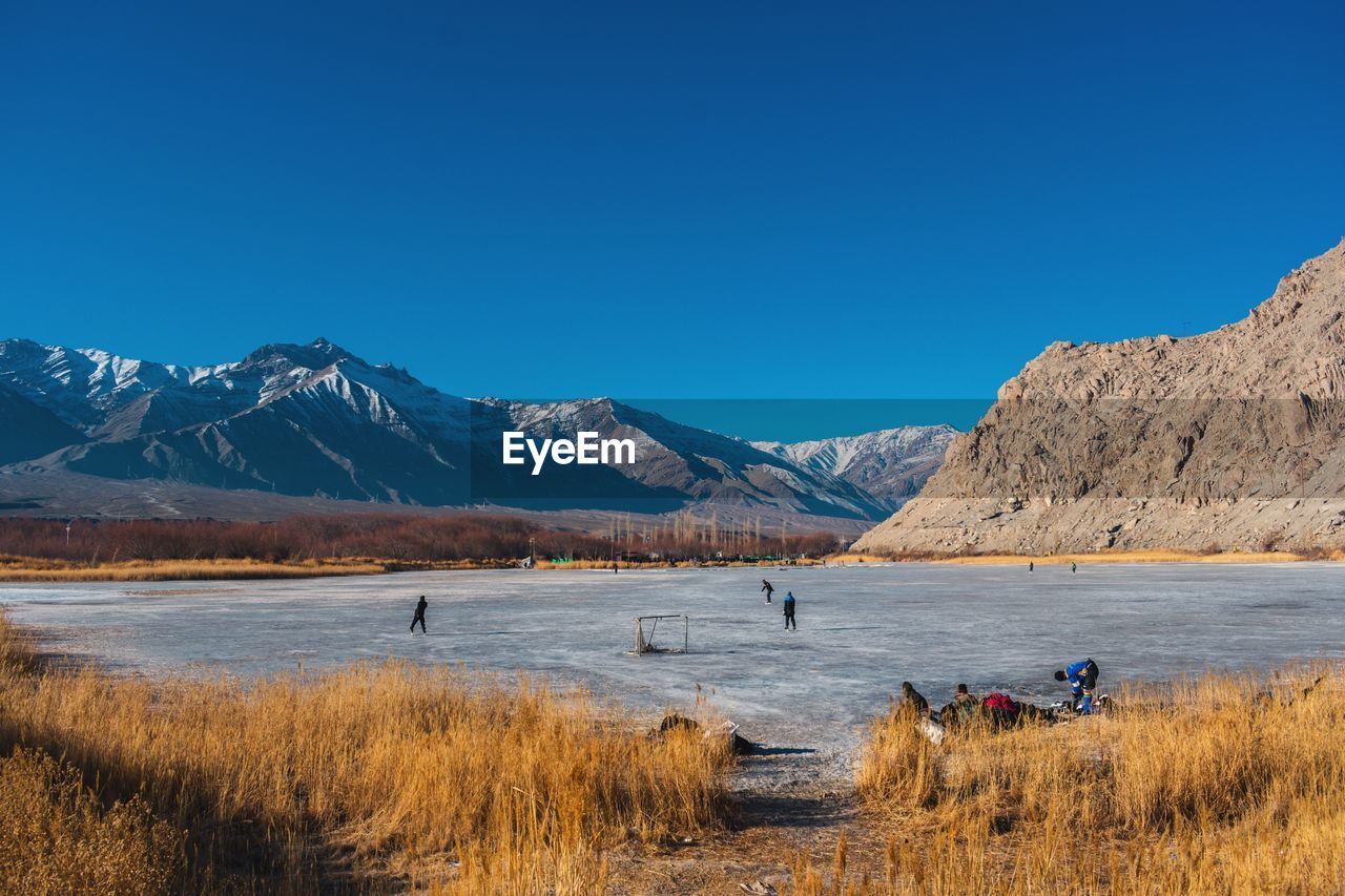 SCENIC VIEW OF LAKE BY MOUNTAINS AGAINST BLUE SKY