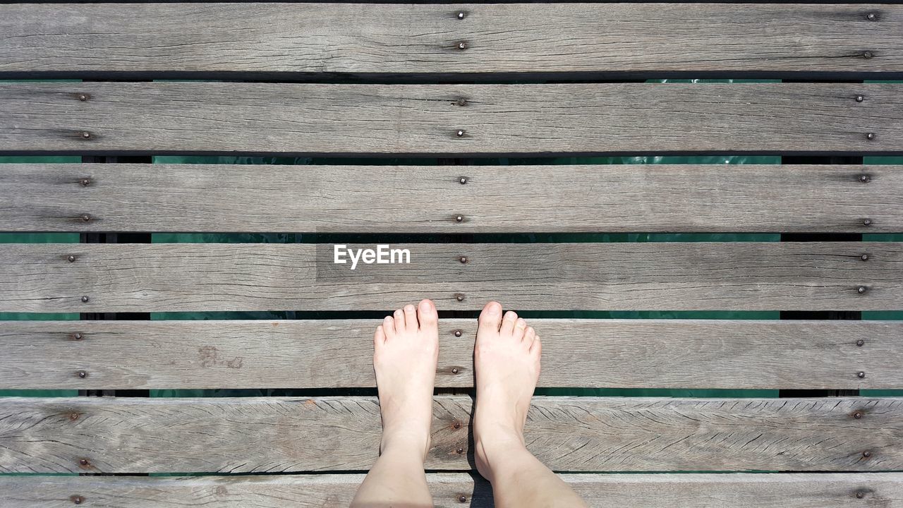 Low section of person legs on pier