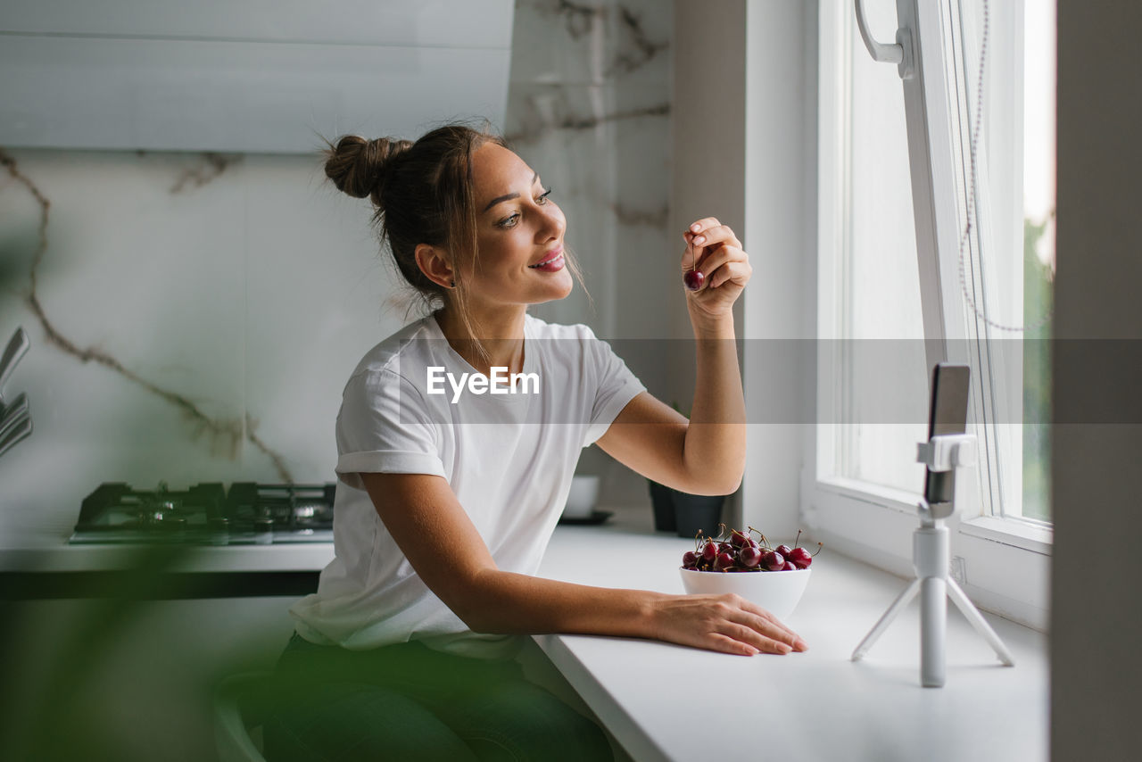 Young woman nutritionist blogger conducts a consultation or an open lesson by video link telling