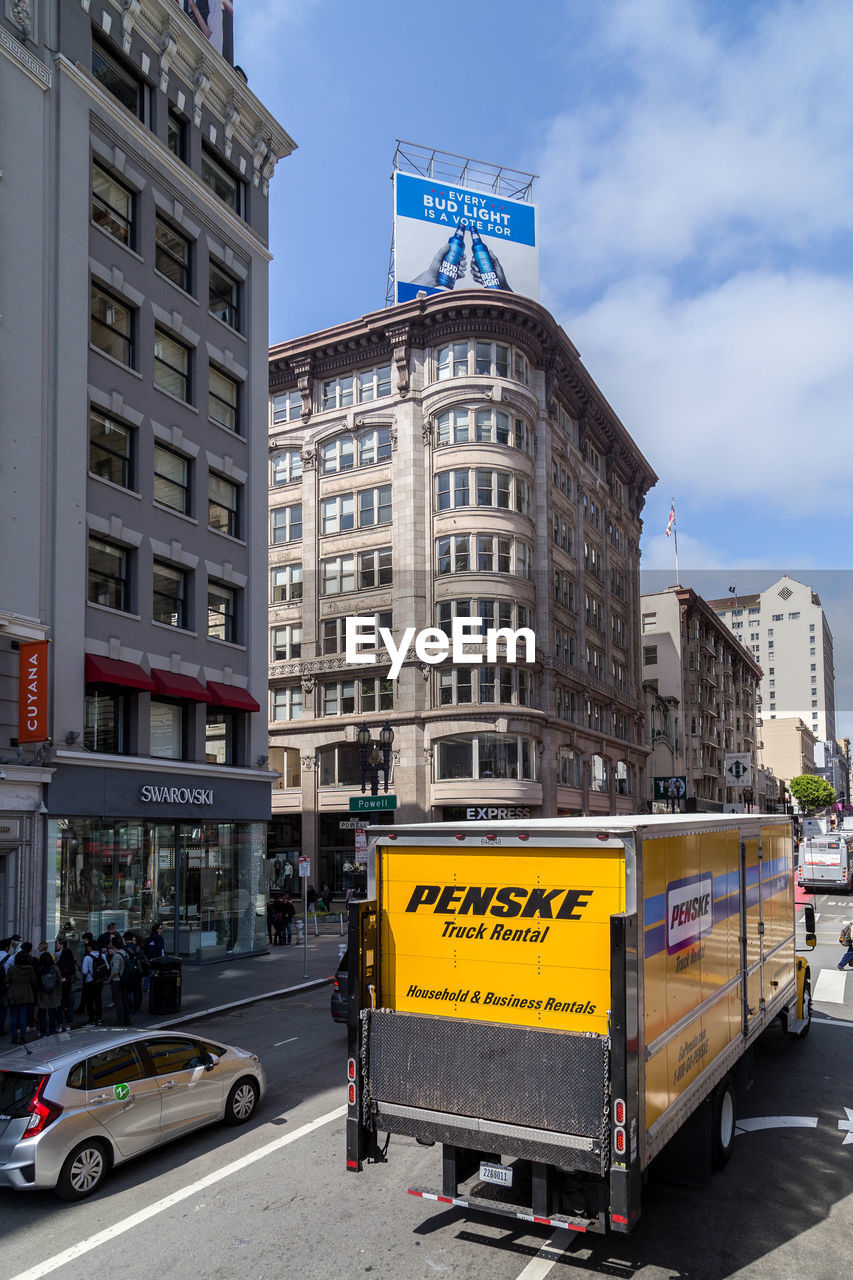 INFORMATION SIGN ON ROAD BY BUILDINGS AGAINST SKY