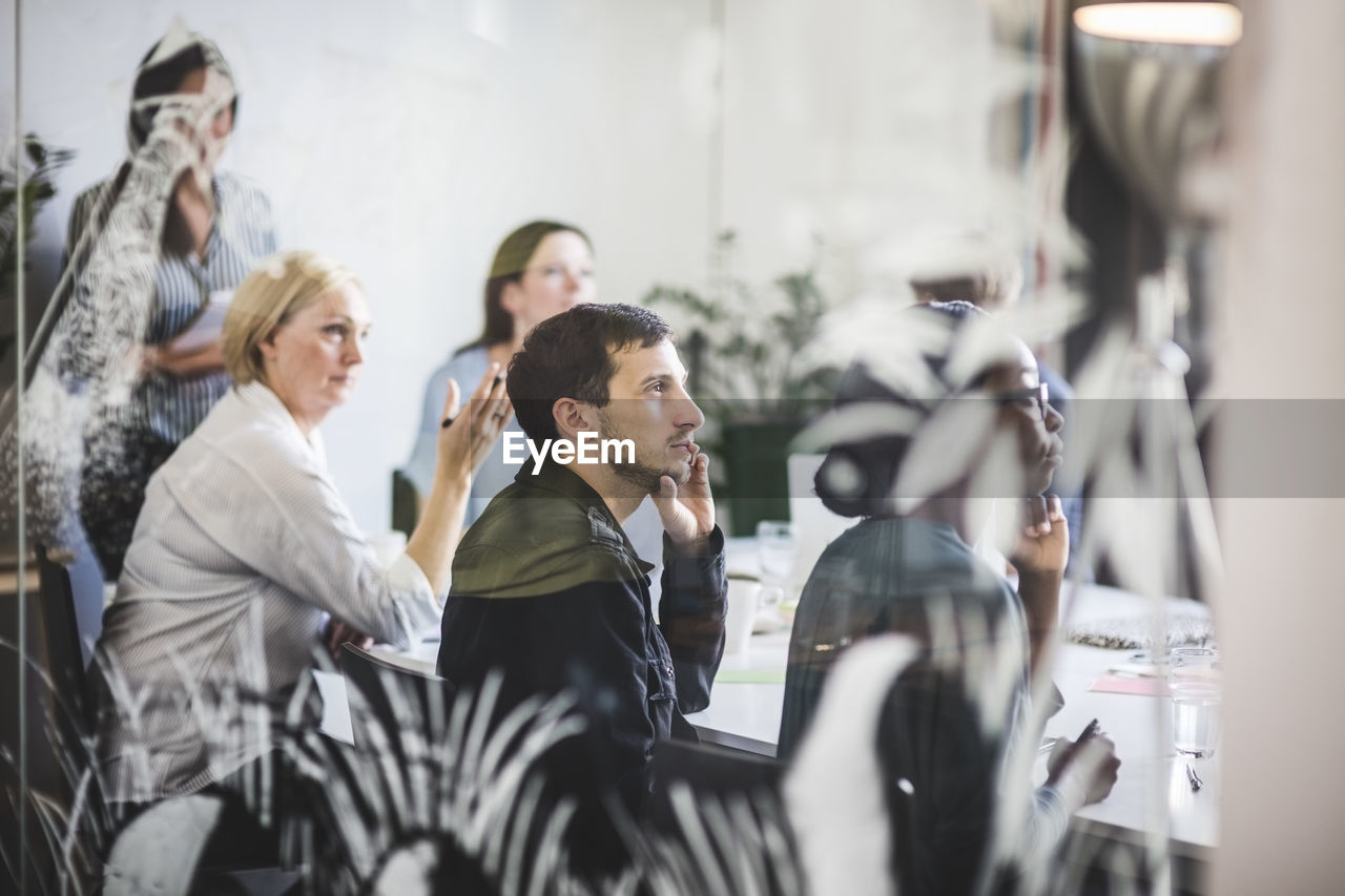 Creative business professionals listening while sitting in conference room