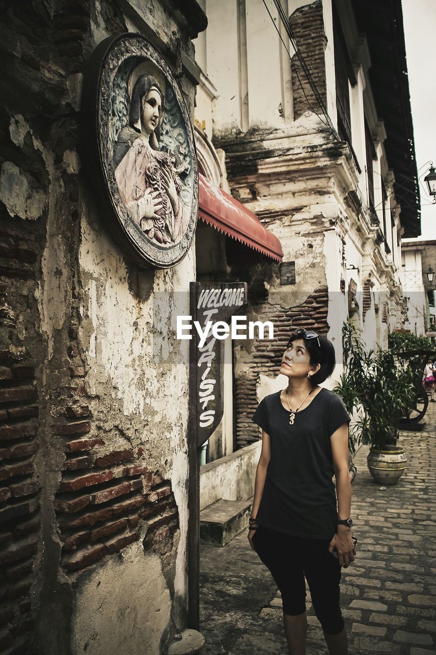 Mid adult woman looking at artwork hanging on wall