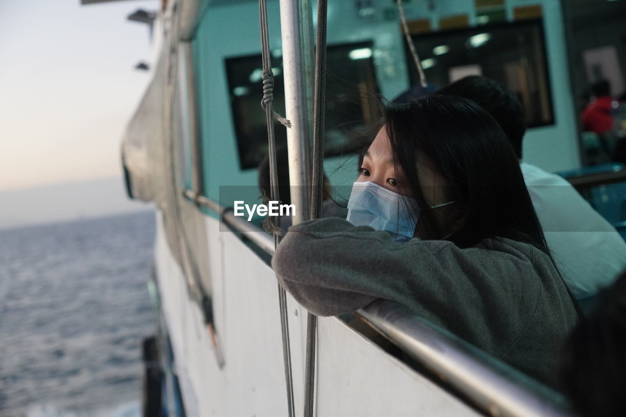 Girl wearing mask standing on boat