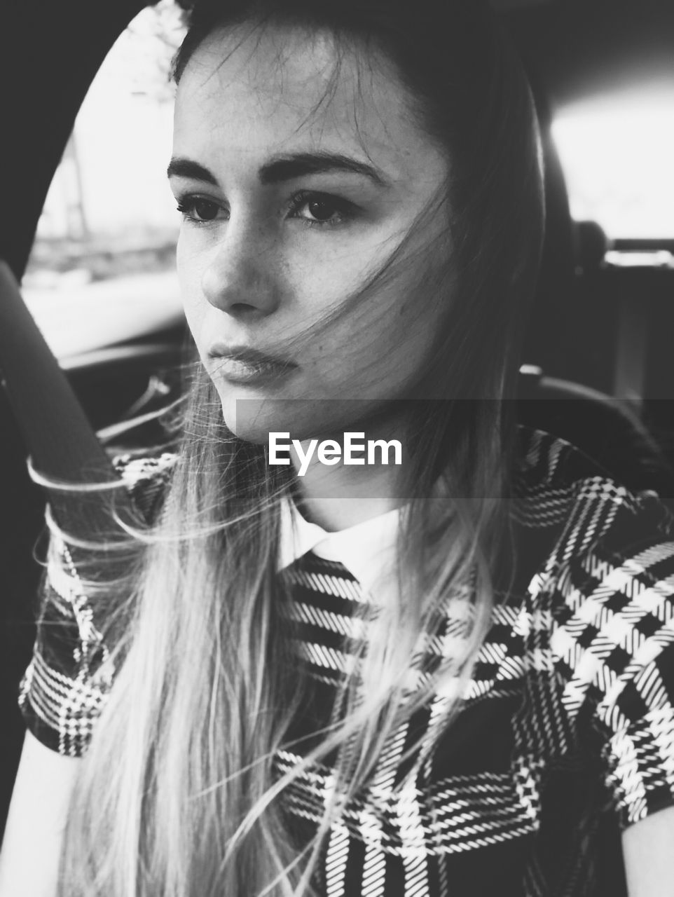 Thoughtful young woman sitting in car