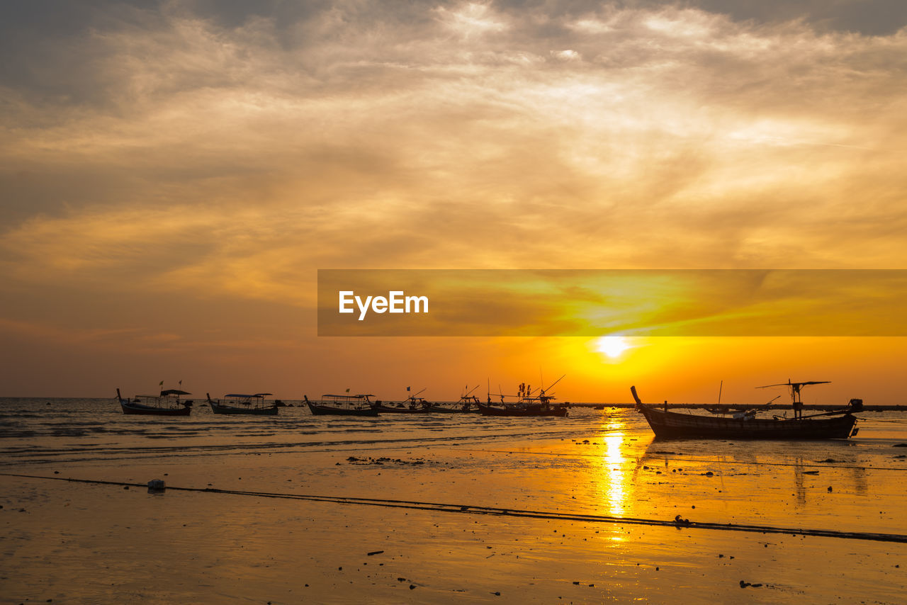 SILHOUETTE BOATS MOORED IN SEA AGAINST SKY DURING SUNSET