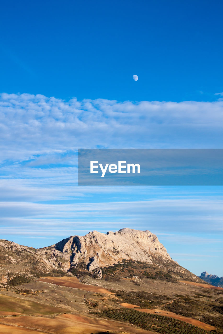 Scenic view of mountain against blue sky