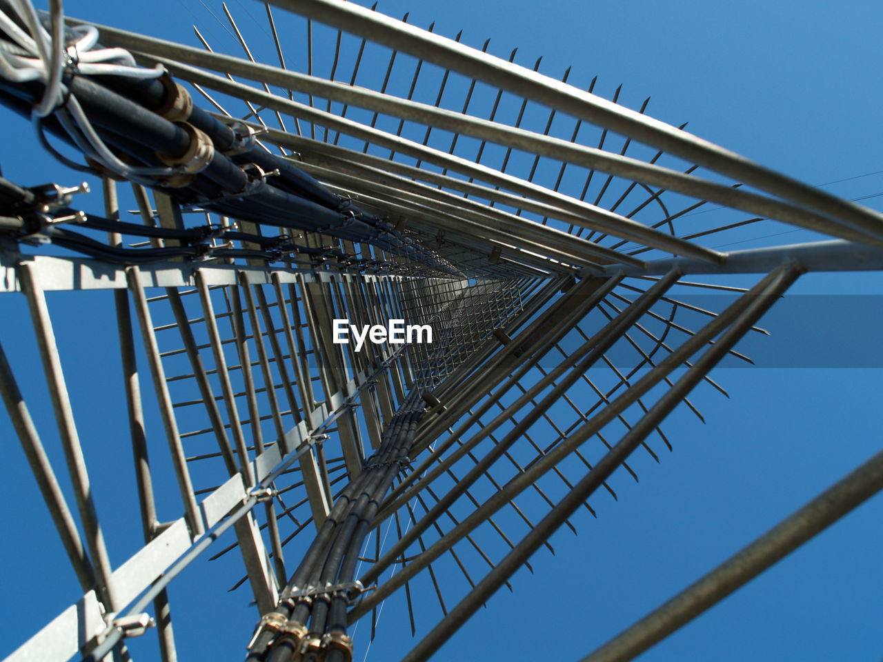 LOW ANGLE VIEW OF METALLIC STRUCTURE AGAINST BLUE SKY AND CLEAR BACKGROUND