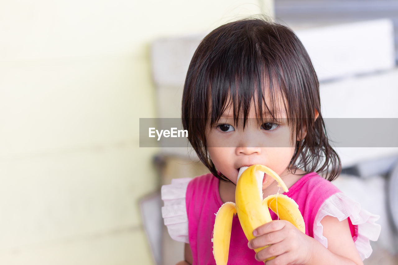 Baby girl eating banana