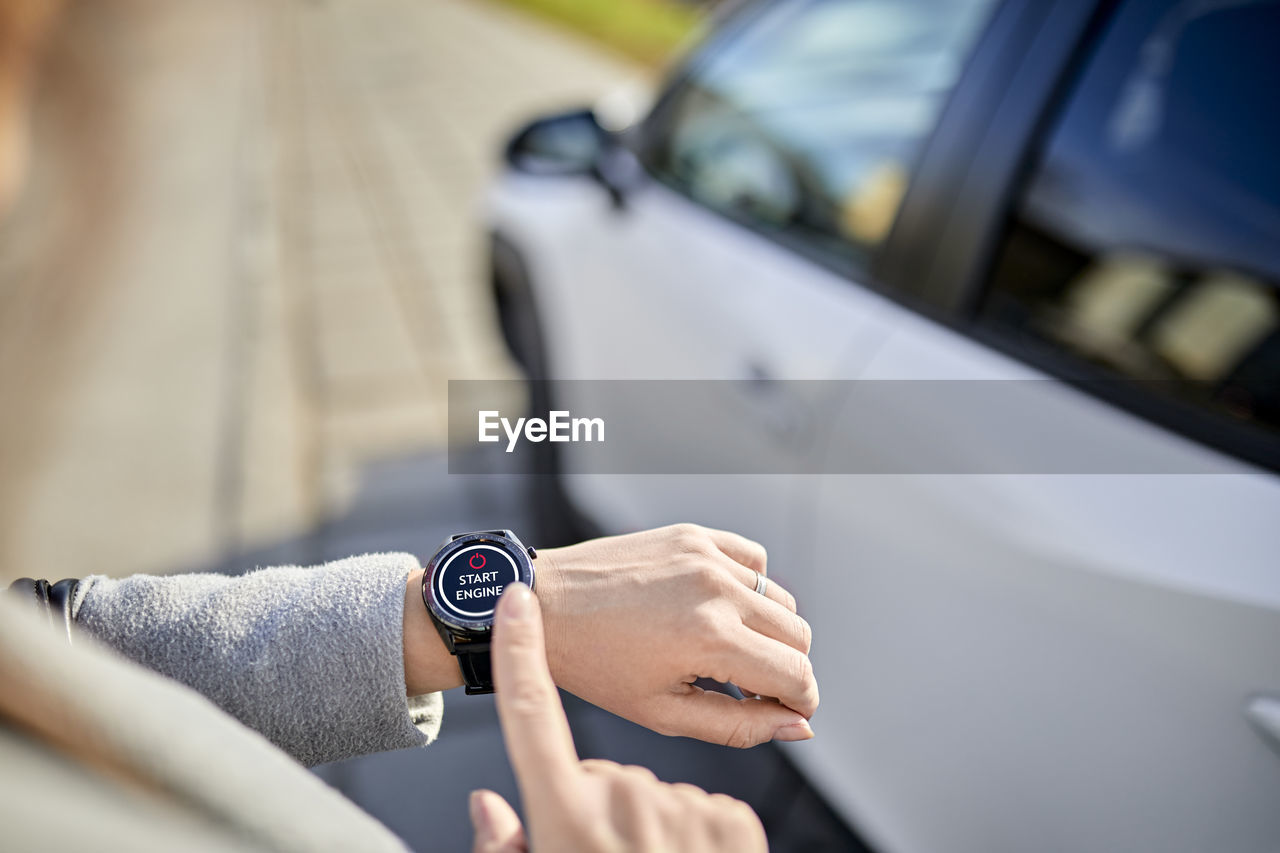 Woman operating car with smart watch