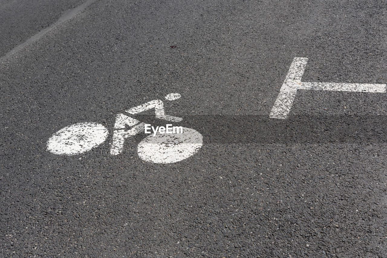 HIGH ANGLE VIEW OF SIGN ON ROAD