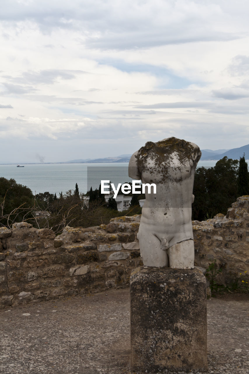 Old ruins statue at byrsa by mediterranean sea against sky