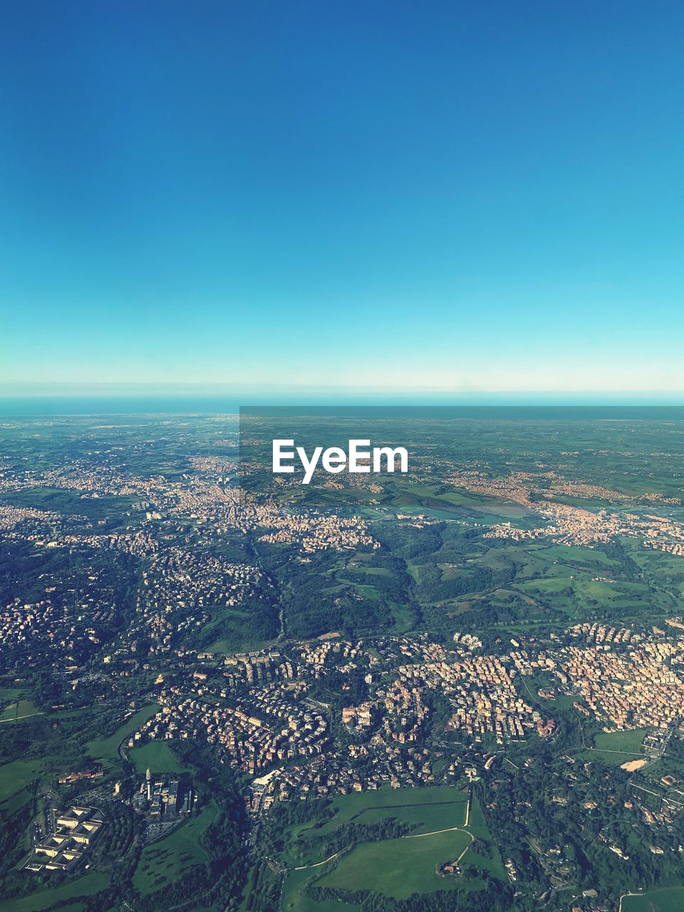 AERIAL VIEW OF TOWNSCAPE AGAINST BLUE SKY