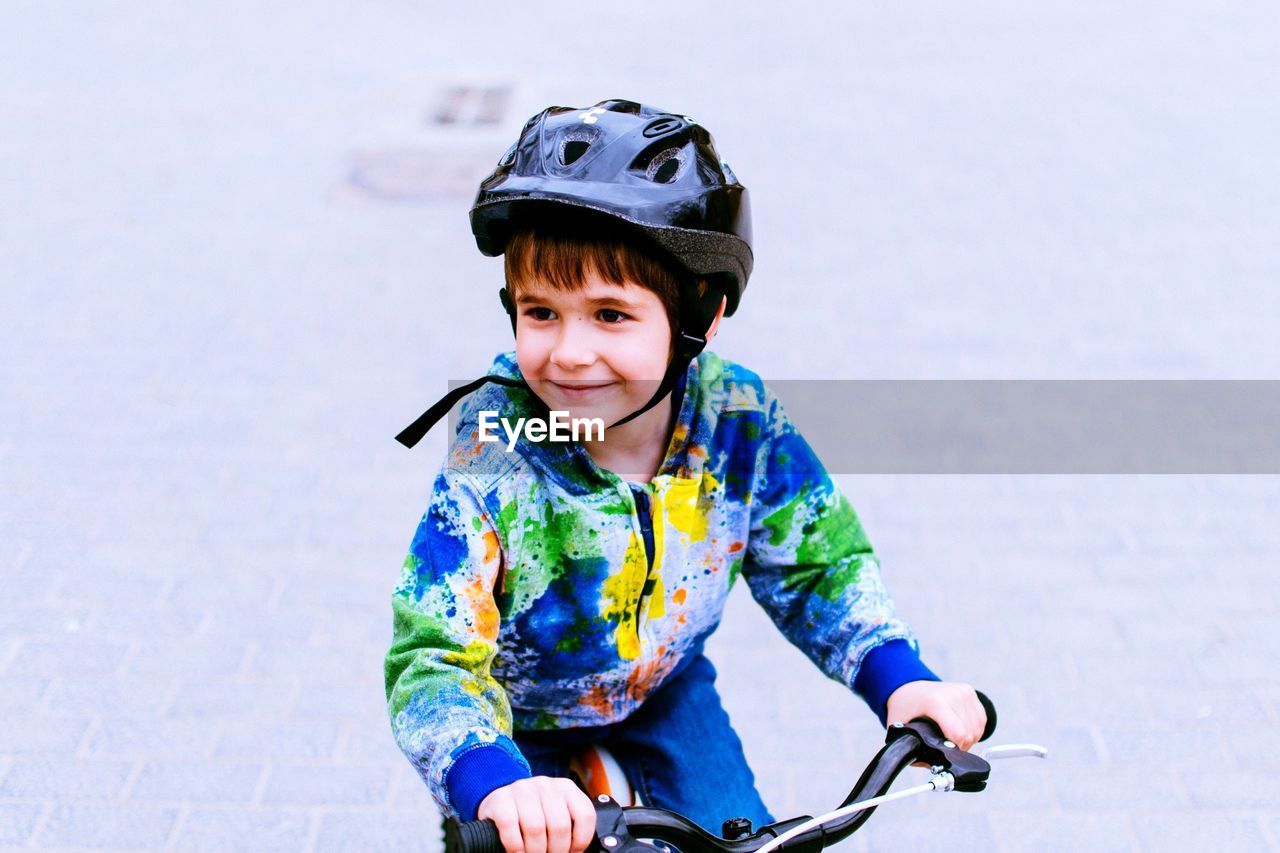 Smiling boy on bicycle looking away